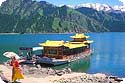 Uygur lady and tourist boat in  Tianchi